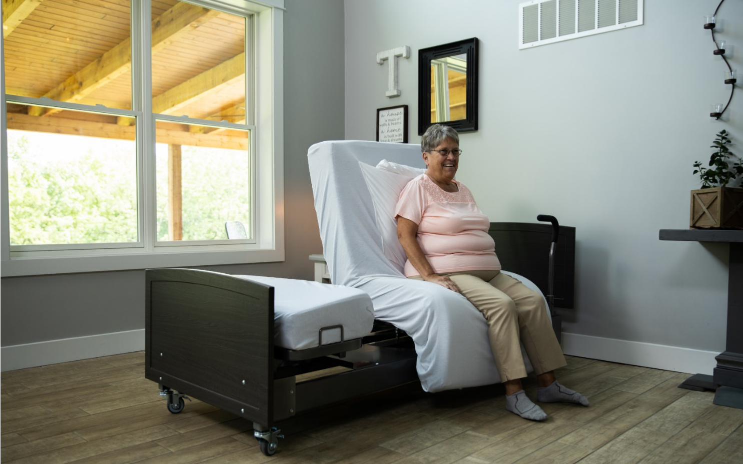 ActiveCare Fixed Height Hospital Bed 2 Image of a woman sitting on the ActiveCare Fixed Height Hospital Bed.