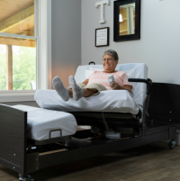 Image of woman laying on the ActiveCare Fixed Height Hospital Bed. thumbnail