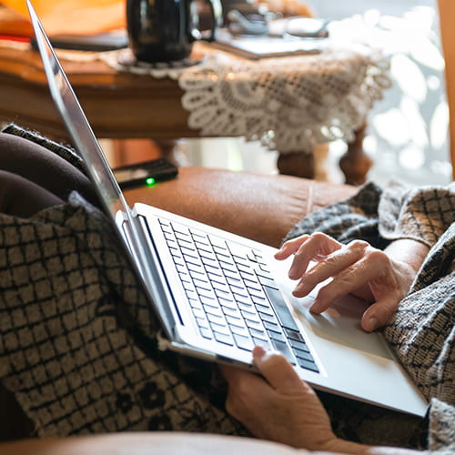 older woman using laptop on the couch